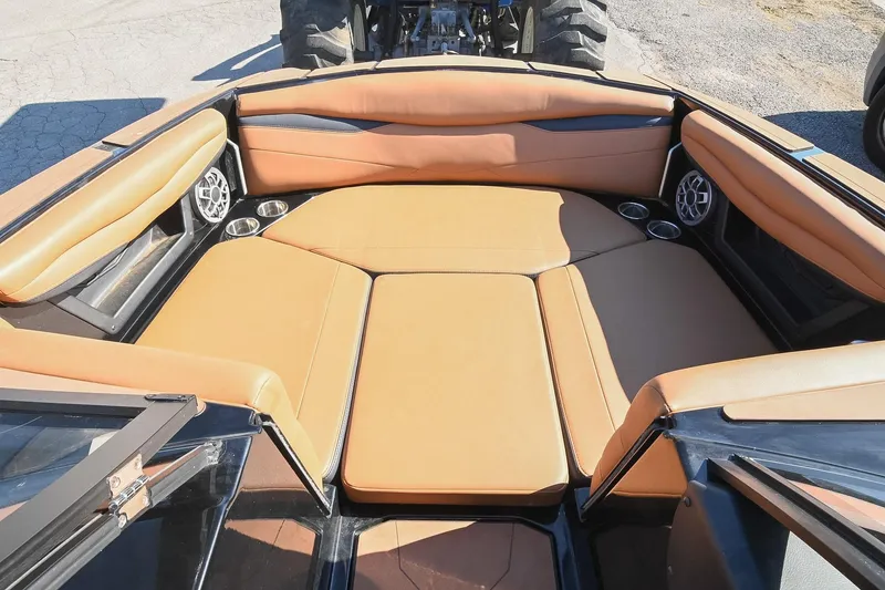 Slide: The Image of 2023 Axis A225 boat interior with tan seating, cup holders, and speakers. - 37