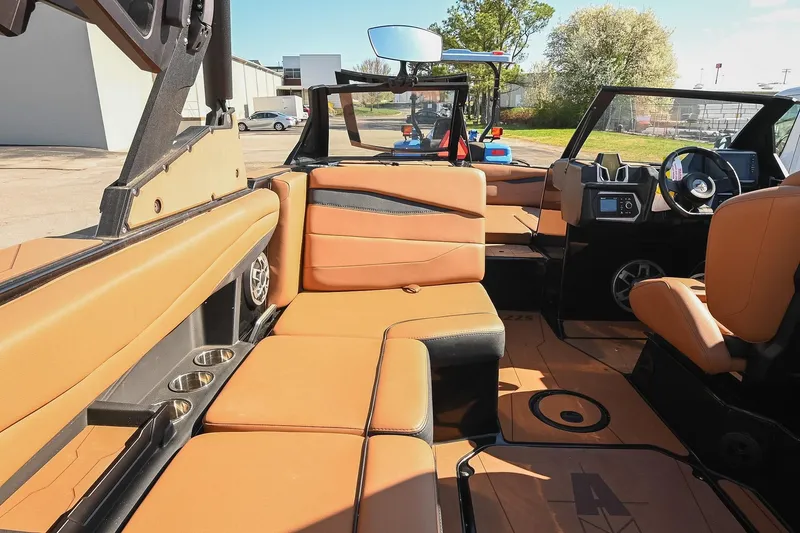 Slide: The Image of 2023 Axis A225 boat interior with tan leather seating and modern dashboard. - 27