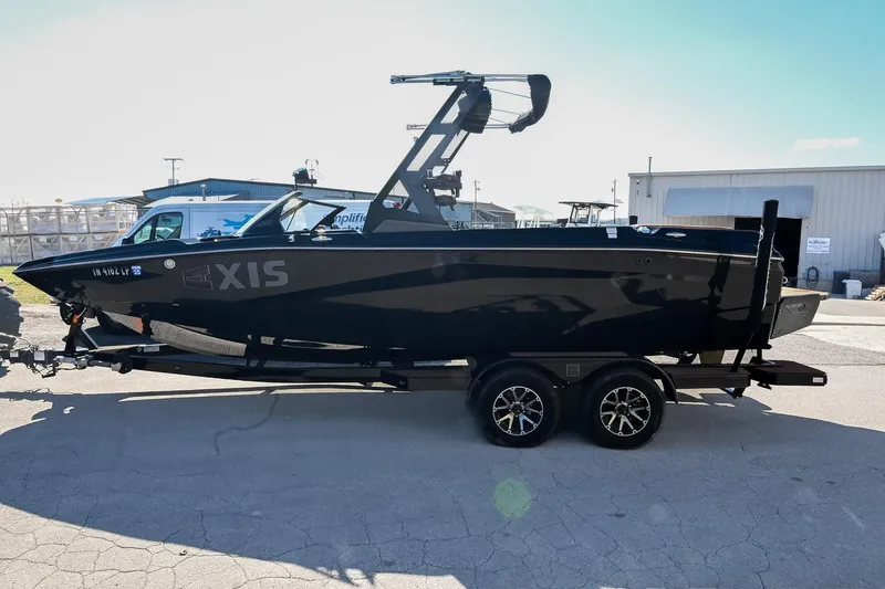 Slide: The Image of 2023 Axis A225 boat on trailer, sleek black design, parked outdoors. - 8
