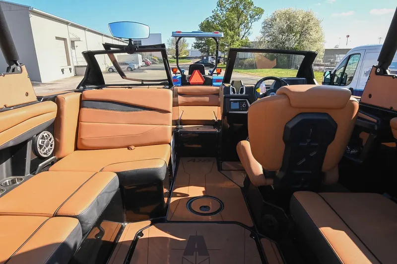 Slide: The Image of 2023 Axis A225 boat interior with tan leather seating and modern dashboard. - 24