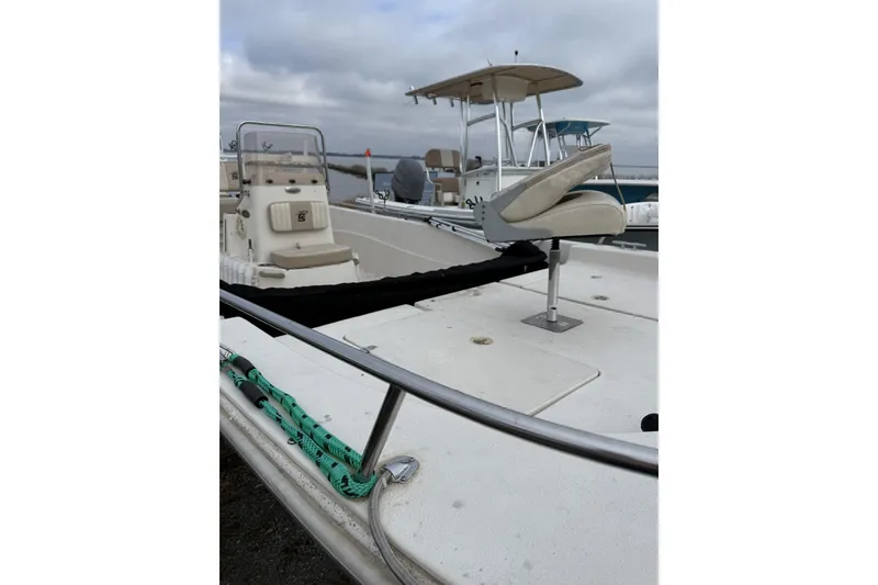 Slide: The Image of 2018 Carolina Skiff 258 DLV boat with seating and railing, docked under cloudy skies. - 2