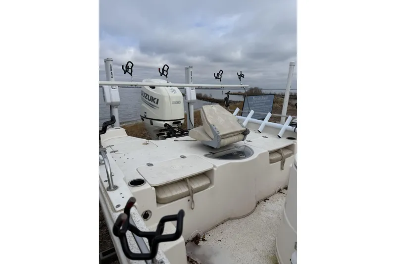 Slide: The Image of 2018 Carolina Skiff 258 DLV boat with Suzuki engine, docked by a lake. - 5