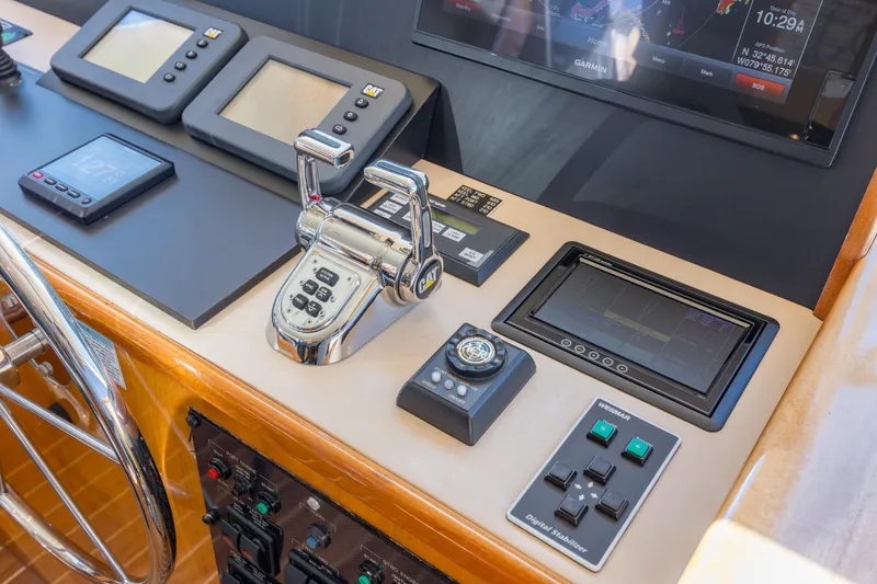 Slide: The Image of Helm controls of a 2007 Hatteras 64 Motor Yacht with navigation displays and throttle levers. - 21