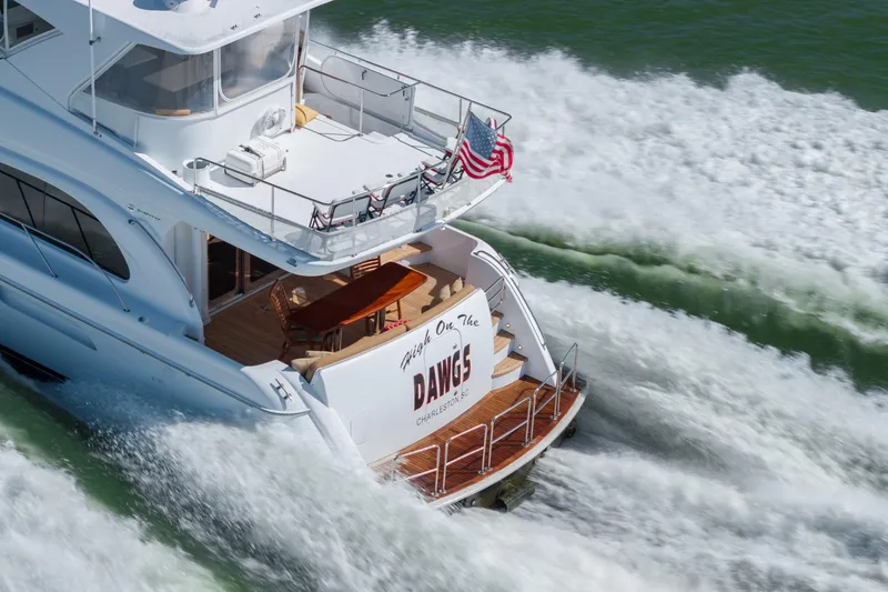Slide: The Image of 2007 Hatteras 64 Motor Yacht cruising with American flag, creating waves. - 3