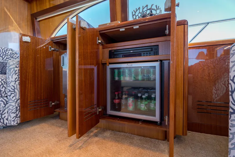 Slide: The Image of Luxurious 2007 Hatteras 64 Motor Yacht interior with mini fridge and wooden cabinetry. - 33