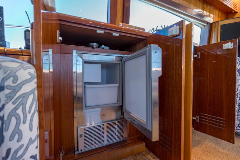Slide: The Image of Open mini fridge in 2007 Hatteras 64 Motor Yacht interior, showcasing wooden cabinetry. - 34