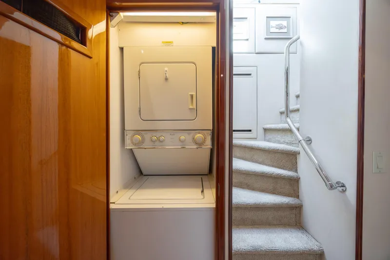 Slide: The Image of Laundry area on 2007 Hatteras 64 Motor Yacht with stairs and wooden paneling. - 45