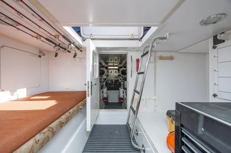 Slide: The Image of Engine room access on 2007 Hatteras 64 Motor Yacht, featuring ladder and fishing rods. - 46