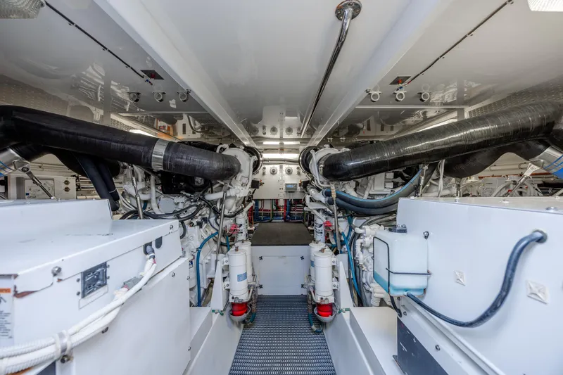 Slide: The Image of Engine room of a 2007 Hatteras 64 Motor Yacht, showcasing machinery and piping. - 49