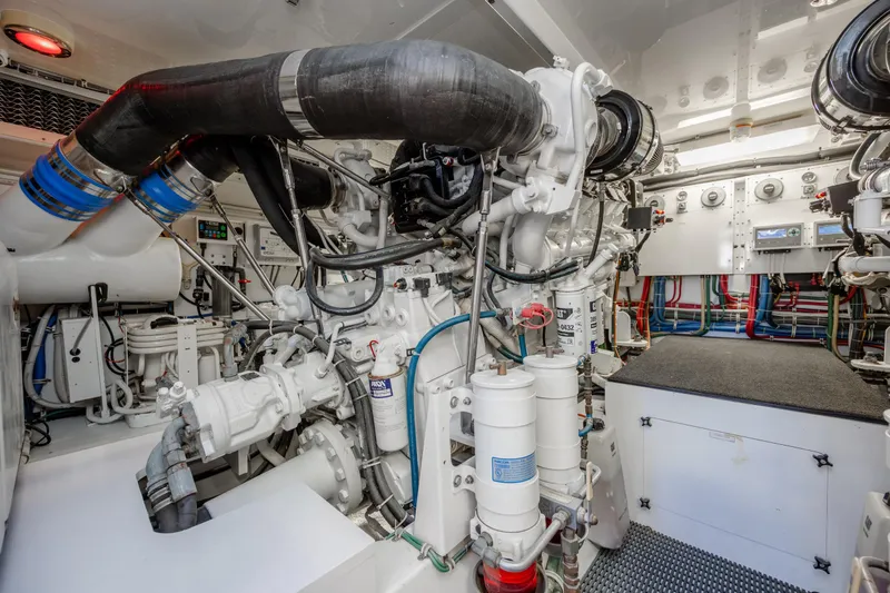 Slide: The Image of Engine room of a 2007 Hatteras 64 Motor Yacht, showcasing complex machinery and piping. - 50