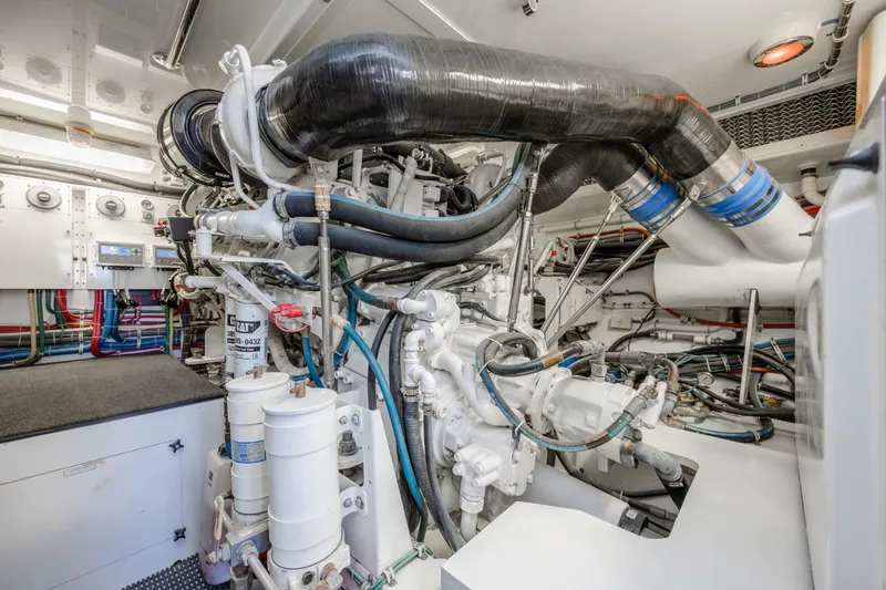 Slide: The Image of Engine room of a 2007 Hatteras 64 Motor Yacht, showcasing complex machinery and piping. - 51