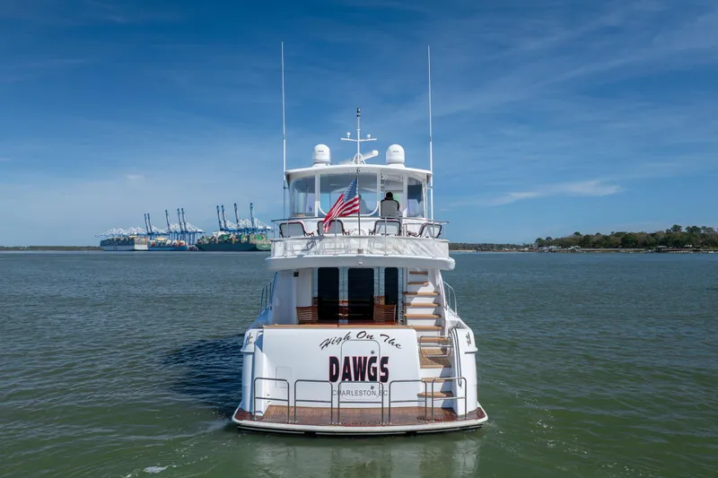 Slide: The Image of 2007 Hatteras 64 Motor Yacht on water, American flag, port in background. - 6