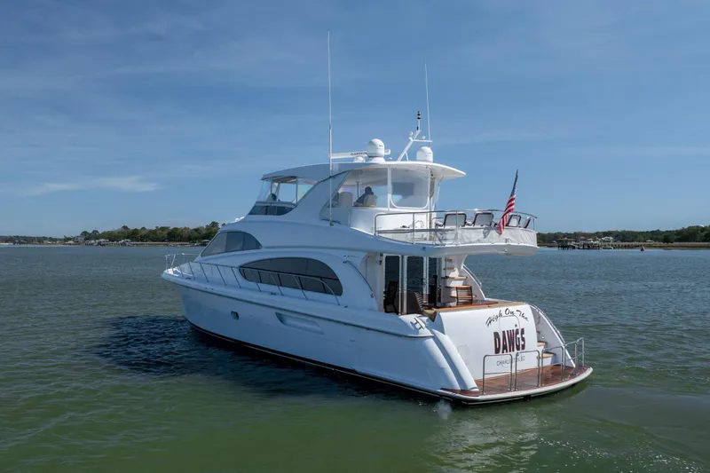 Slide: The Image of 2007 Hatteras 64 Motor Yacht cruising on calm waters under a clear blue sky. - 7
