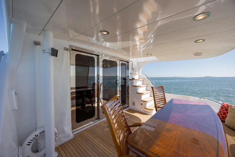 Slide: The Image of Luxurious 2007 Hatteras 64 Motor Yacht deck with elegant seating and ocean view. - 9
