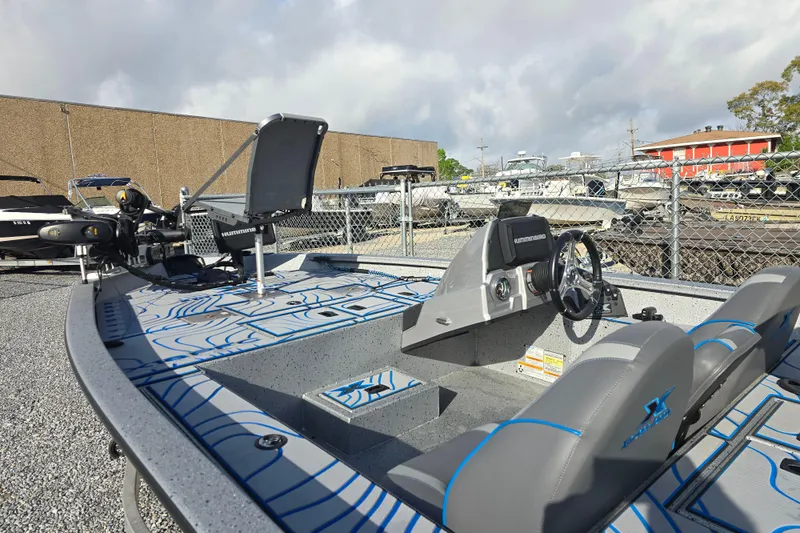 Slide: The Image of 2022 Xpress H18C Crappie boat with modern seating and steering, parked outdoors. - 15