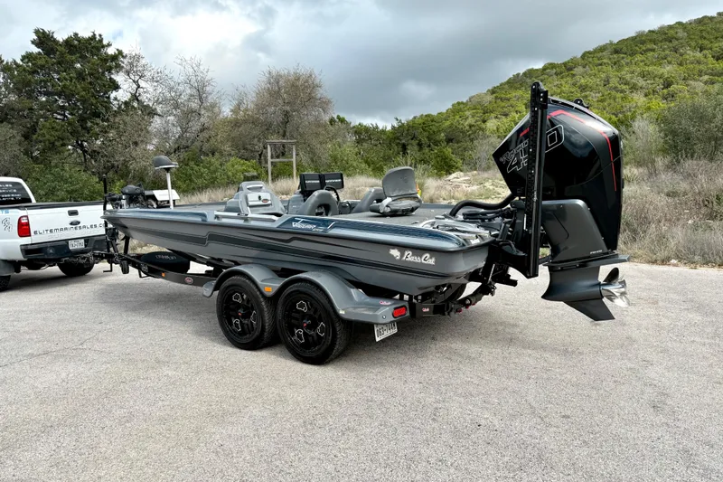 Slide: The Image of 2023 Bass Cat Jaguar STS boat on trailer, parked outdoors with scenic background. - 12