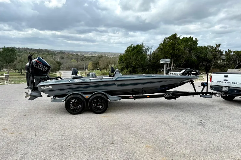 Slide: The Image of 2023 Bass Cat Jaguar STS boat on trailer, parked outdoors under cloudy sky. - 15