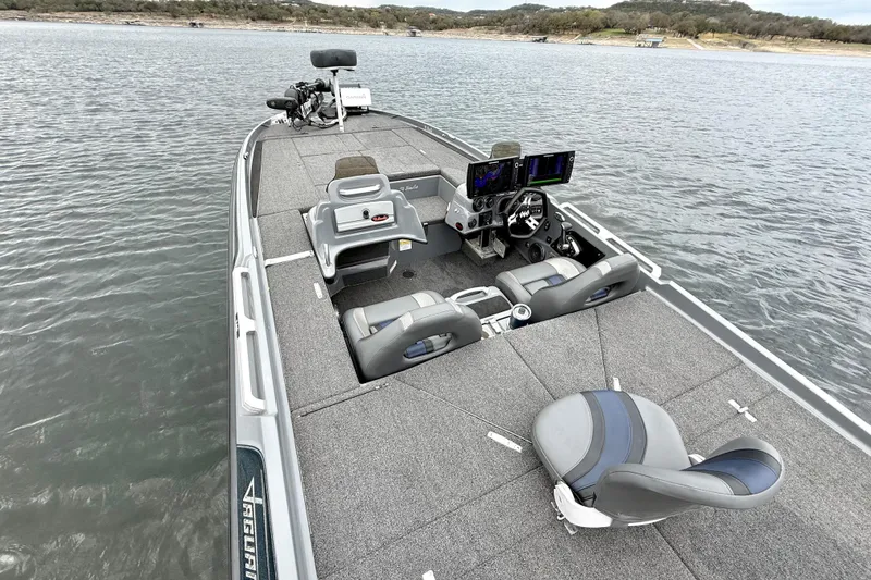 Slide: The Image of 2023 Bass Cat Jaguar STS boat interior with advanced navigation systems on a calm lake. - 18