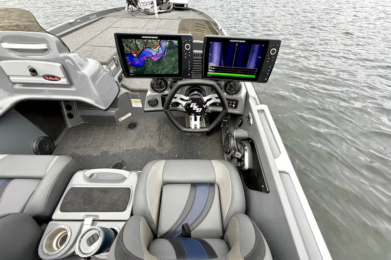 Slide: The Image of 2023 Bass Cat Jaguar STS boat interior with advanced navigation displays on water. - 22