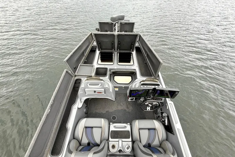 Slide: The Image of 2023 Bass Cat Jaguar STS boat interior with advanced navigation system and seating on water. - 25