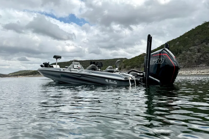 Slide: The Image of 2023 Bass Cat Jaguar STS boat on a serene lake with cloudy skies. - 3