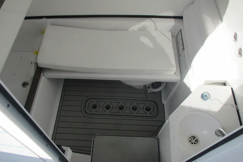Slide: The Image of 2026 Sportsman Open 302 Center Console interior with cushioned seating and compact sink. - 16