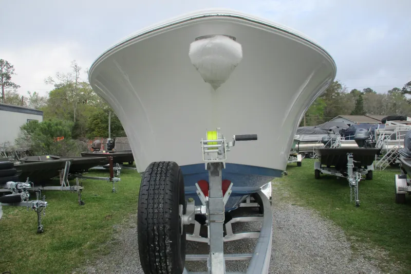 Slide: The Image of 2026 Sportsman Open 302 Center Console boat on trailer, front view, outdoors. - 2