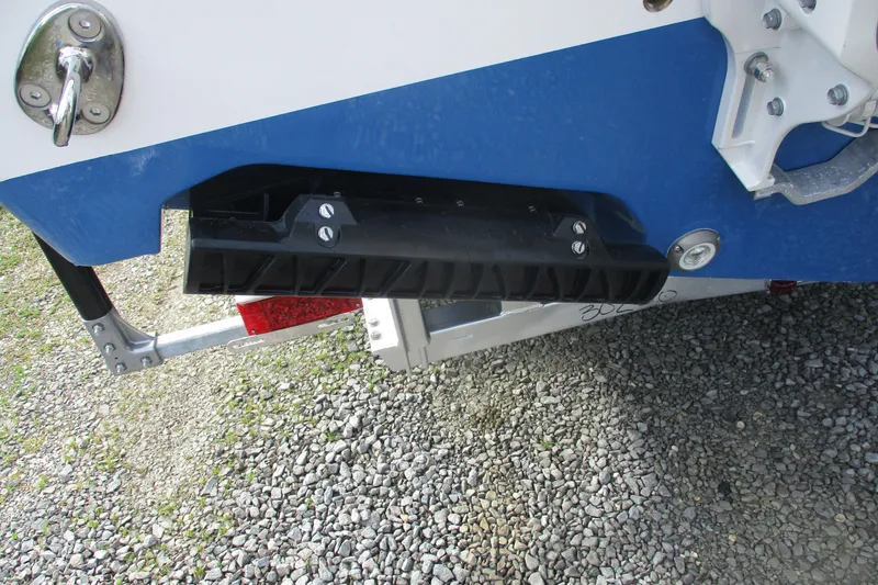 Slide: The Image of 2026 Sportsman Open 302 Center Console boat trailer detail on gravel surface. - 20