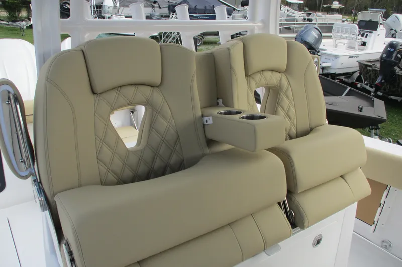 Slide: The Image of 2026 Sportsman Open 302 Center Console boat seats with cup holders, featuring beige upholstery. - 6