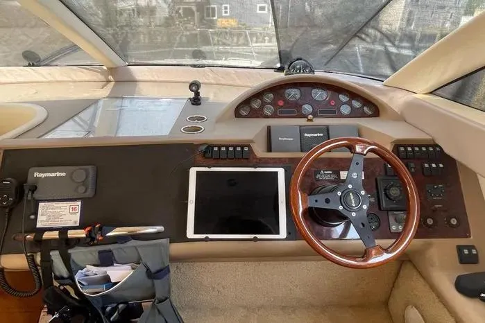 Slide: The Image of 2001 Viking Princess boat dashboard with steering wheel, navigation equipment, and tablet holder. - 11