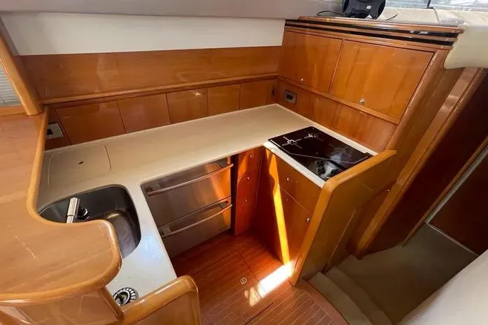 Slide: The Image of 2001 Viking Princess yacht kitchen with wood cabinetry, stainless steel appliances, and compact design. - 12