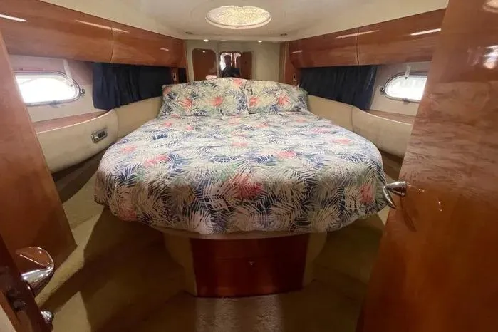 Slide: The Image of Luxurious 2001 Viking Princess yacht bedroom with floral bedding and elegant wood finishes. - 5