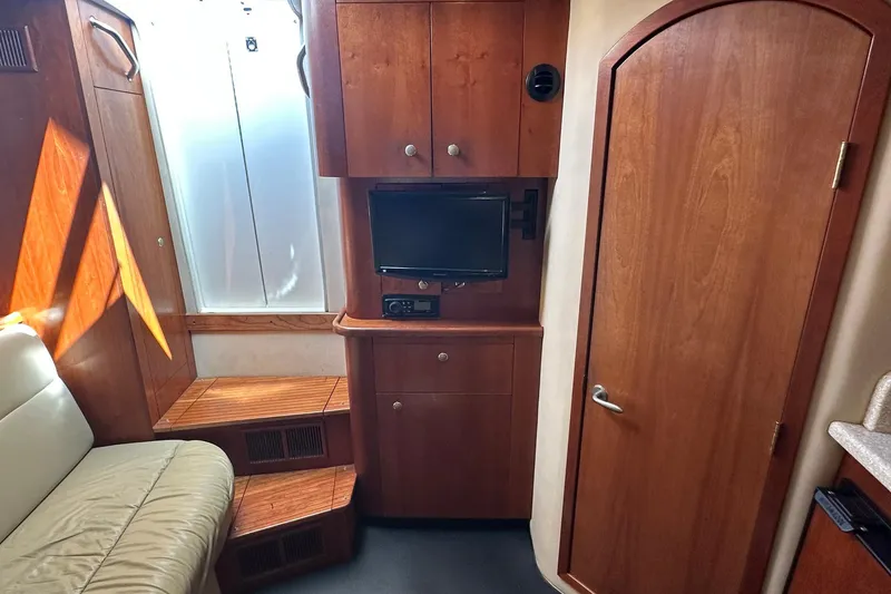 Slide: The Image of Interior of 2006 Rampage 33 Express boat with wood cabinetry and small TV. - 17