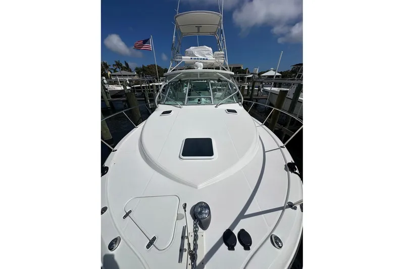 Slide: The Image of 2006 Rampage 33 Express boat docked, featuring sleek white deck and American flag. - 4