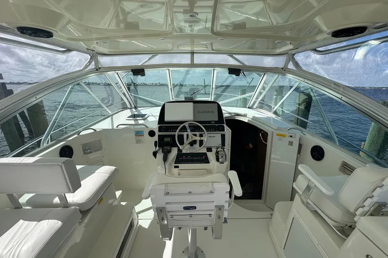 Slide: The Image of 2006 Rampage 33 Express boat interior with helm, white seating, and ocean view. - 7