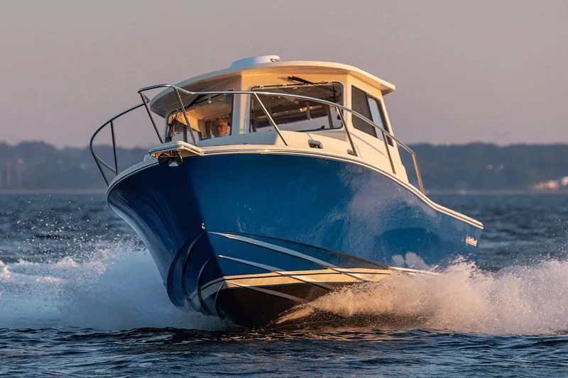 Slide: The Image of Manufacturer Provided Image: 2026 NorthCoast 315 HT boat cruising on open water at sunset. - 2