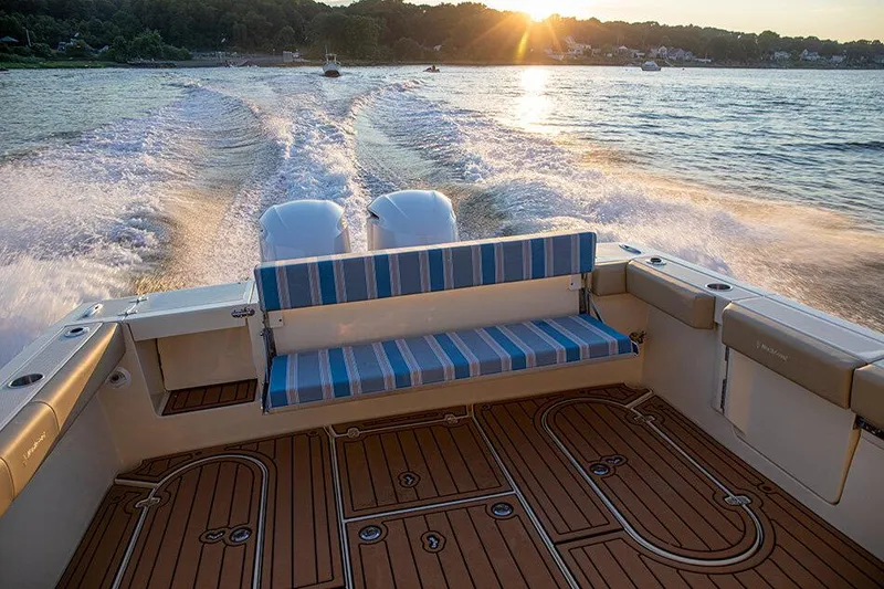 Slide: The Image of Manufacturer Provided Image: 2026 NorthCoast 315 HT boat cruising at sunset with striped seating and wooden deck. - 7