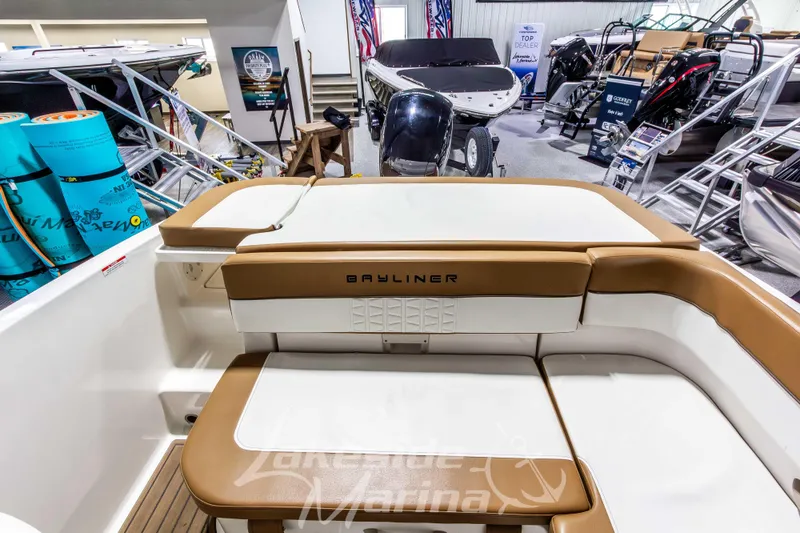 Slide: The Image of 2022 Bayliner VR5 Bowrider OB interior at a marina showroom, showcasing seating and equipment. - 10