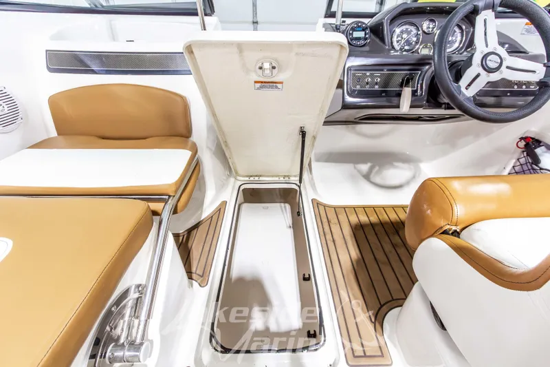 Slide: The Image of 2022 Bayliner VR5 Bowrider OB interior with open storage compartment and tan seating. - 24