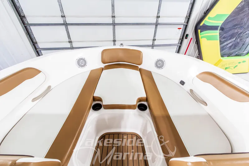 Slide: The Image of 2022 Bayliner VR5 Bowrider OB interior with tan and white seating in a garage. - 26