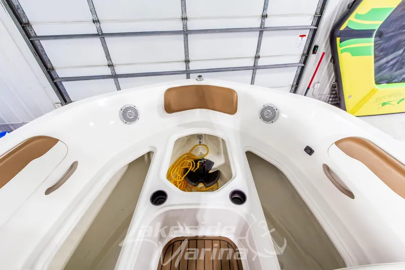 Slide: The Image of 2022 Bayliner VR5 Bowrider OB interior with storage and seating in a marina setting. - 27