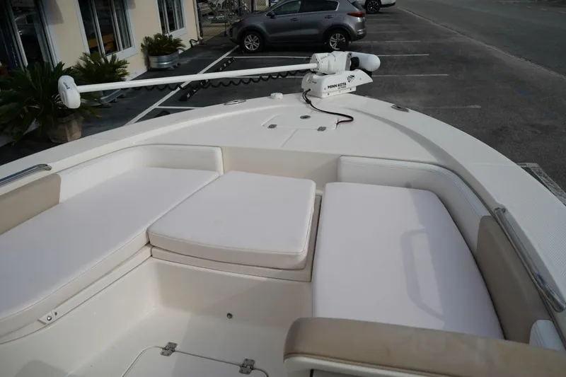 Slide: The Image of 2020 Robalo 226 Cayman boat interior with cushioned seating and Minn Kota trolling motor. - 15