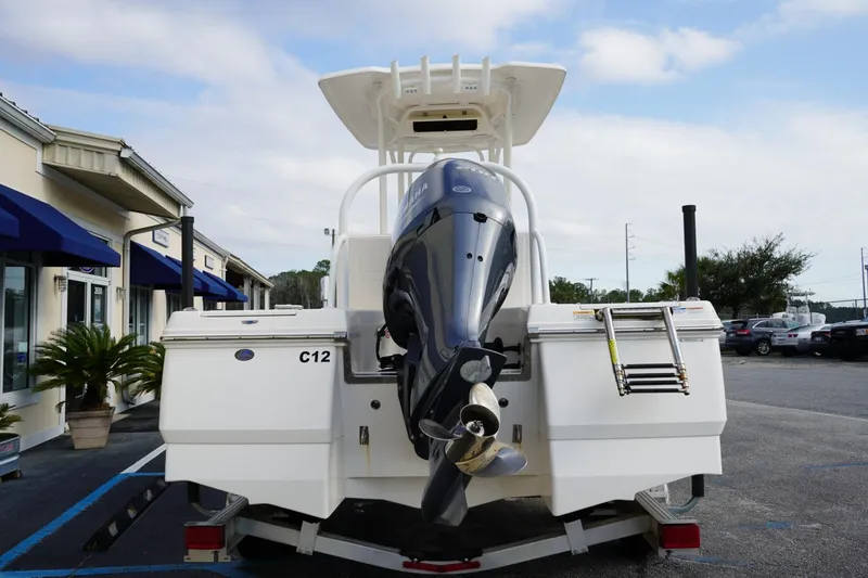 Slide: The Image of 2020 Robalo 226 Cayman boat with outboard motor, parked outside a building. - 2