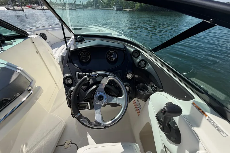 Slide: The Image of 2015 Monterey 264FS boat cockpit with steering wheel and controls, docked by the water. - 7