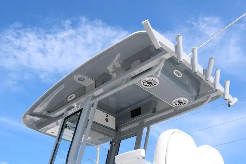 Slide: The Image of 2026 Sea Fox 282 Hybrid LT boat top view with rod holders and speakers against blue sky. - 7