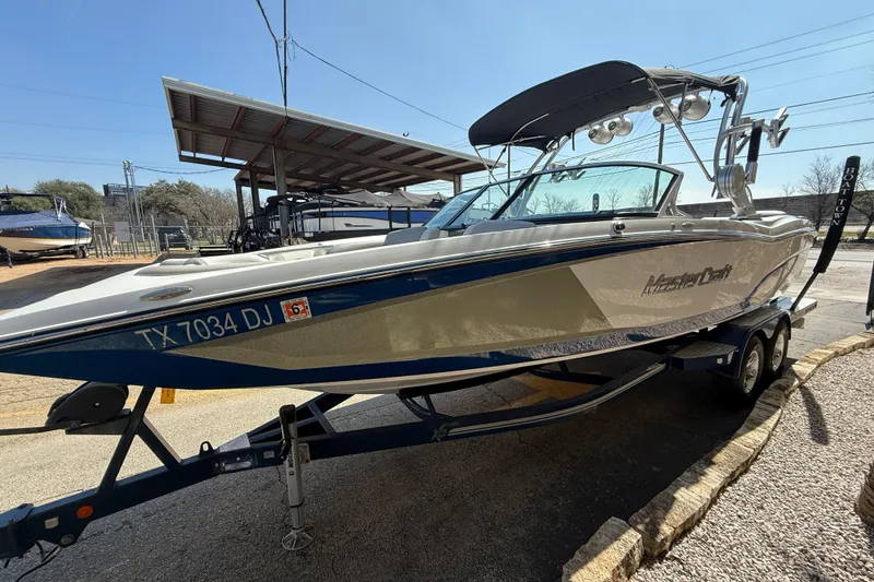 Slide: The Image of 2016 MasterCraft X46 boat on trailer, parked outdoors under clear sky. - 4