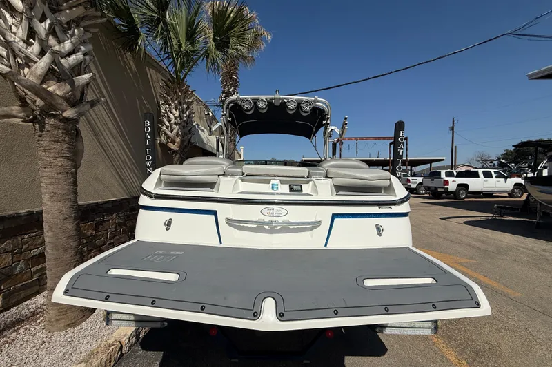 Slide: The Image of 2016 MasterCraft X46 boat rear view with swim platform, parked near palm trees. - 6