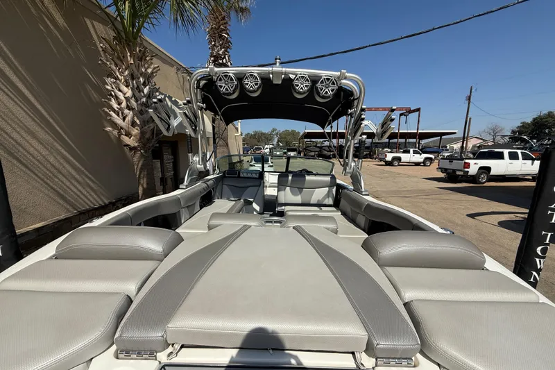 Slide: The Image of 2016 MasterCraft X46 boat interior with seating and speakers, parked outdoors. - 8