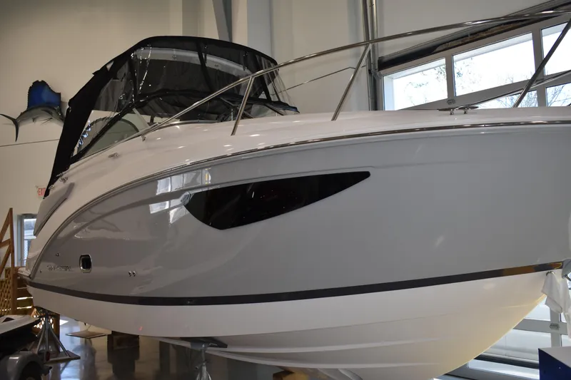 The Image of 2026 Regal 26 XO boat in showroom, sleek design with black canopy. - 0