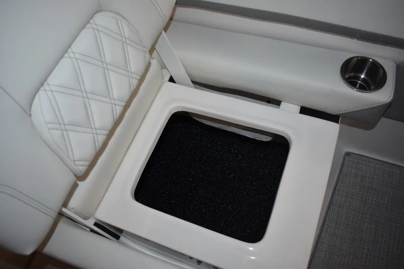 Slide: The Image of 2026 Regal 26 XO boat interior with white cushioned seating and built-in cup holder. - 16